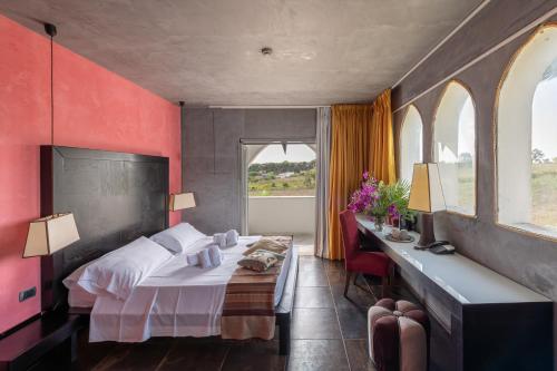 1 Schlafzimmer mit einem Bett, einem Schreibtisch und 2 Fenstern in der Unterkunft Amareclub Baia Dei Turchi Resort - Adults Only in Otranto