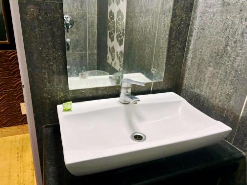 a white sink in a bathroom with a mirror at Hotel Ganga Near Mall Road in Shimla