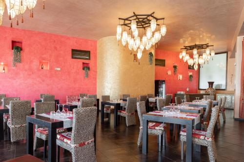 a dining room with tables and chairs and a chandelier at Amareclub Baia Dei Turchi Resort - Adults Only in Otranto