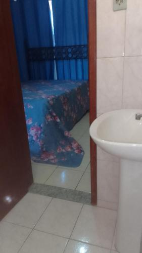 een badkamer met een wastafel en een bed bij Hospedaria Meu lar in Rio das Ostras