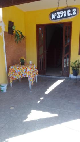 una mesa frente a un edificio con una señal en Hospedaria Meu lar en Rio das Ostras
