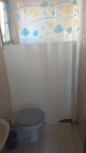a bathroom with a blue toilet and a curtain at Hospedaria Meu lar in Rio das Ostras