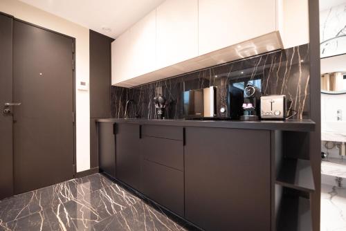 une cuisine avec un comptoir noir dans une pièce dans l'établissement Lovely Home - LOUVRE MUSEUM, à Paris