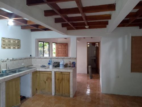 cocina con paredes blancas y armarios de madera en Casa Qi Boho B&B en Cabuya