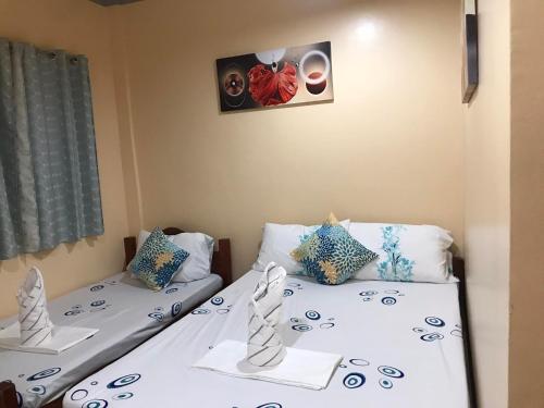 two twin beds in a room with at INDINO GUEST HOUSE 2 in Moalboal