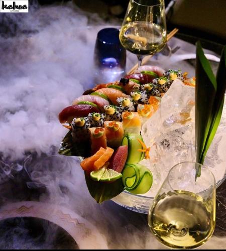 a plate of food with fruit and a glass of wine at NYX Esperia Palace Hotel Athens by Leonardo Hotels in Athens