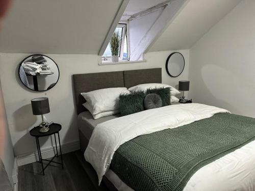 a bedroom with a bed with a green blanket and pillows at Studio Flat Near City Centre in Newport