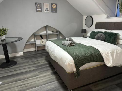 a bedroom with a large bed and a table at Studio Flat Near City Centre in Newport