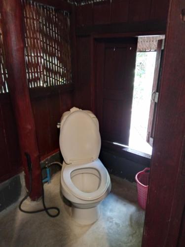 a bathroom with a white toilet in a room at Room 2 in Ban Tham
