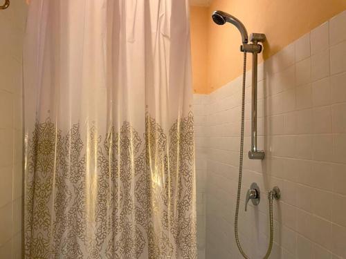 e bagno con doccia con tenda bianca. di Farmhouse with pool in the Chianti a Montefiridolfi