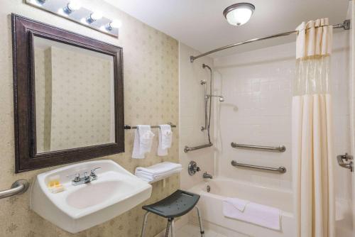 a bathroom with a sink and a tub and a shower at Ramada by Wyndham Lumberton in Lumberton