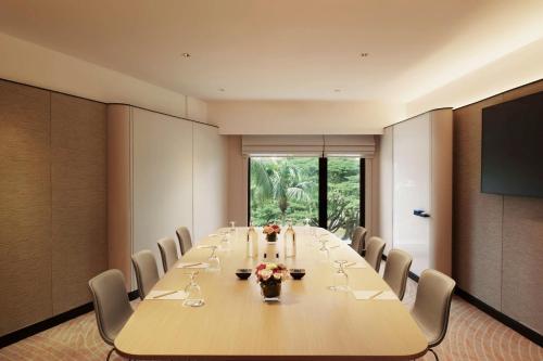 a conference room with a long table and chairs at Hilton Kuching Hotel in Kuching