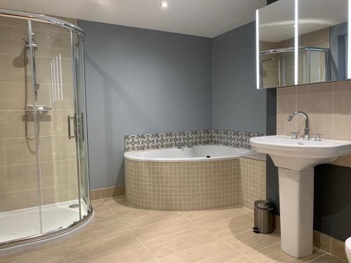 een badkamer met een bad, een wastafel en een douche bij Lakeview Lodge in Newtown Butler
