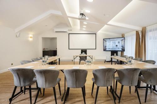 a conference room with a table and chairs and a projection screen at St Palace Hotel in Vilnius