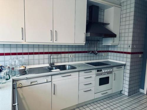 a kitchen with white cabinets and a sink at Personalunterkunft nahe Euregio-Klinik Nordhorn 1 in Nordhorn