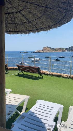 een bank en stoelen op een strand met uitzicht op de oceaan bij White Cap Sa Sal in Girona