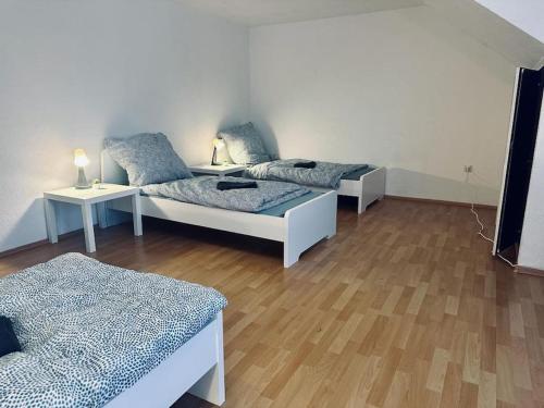 een kamer met drie bedden en twee tafels met lampen bij Personalunterkunft nahe Euregio-Klinik Nordhorn 2 in Nordhorn