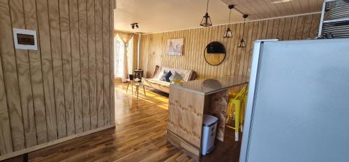 een woonkamer met een koelkast en een bank bij Loft playa blanca ruta160 in Coronel
