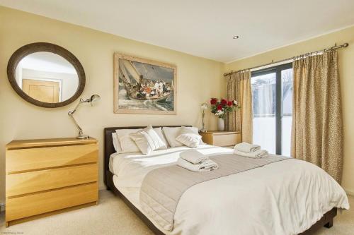 a bedroom with a large bed and a mirror at Seafront Quay West Apartments in Cowes