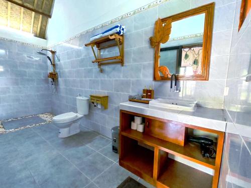 a bathroom with a sink and a toilet at Meket Bungalows in Nusa Penida