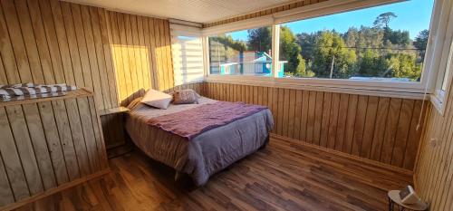 1 dormitorio con 1 cama en una habitación con ventana en Loft playa blanca ruta160, en Coronel
