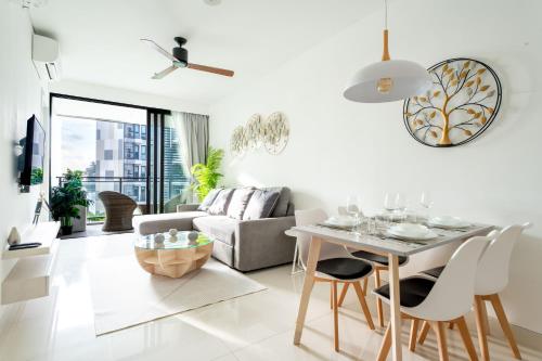 邦濤海灘的住宿－Cassia Residences by NLA，客厅配有桌子和沙发