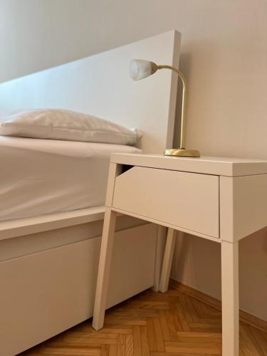 a desk with a lamp next to a bed at Der Landsitz in Klagenfurt