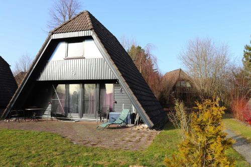 ein kleines Haus mit einem Gameradach in der Unterkunft Ferienhaus Winnetou Schwarzkittelpfad 85 in Waldbrunn