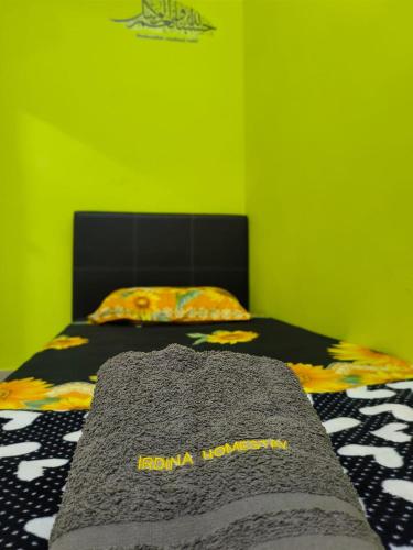 a bedroom with a bed with a green wall at IRDINA HOMESTAY forMuslims - Changlun in Changlun