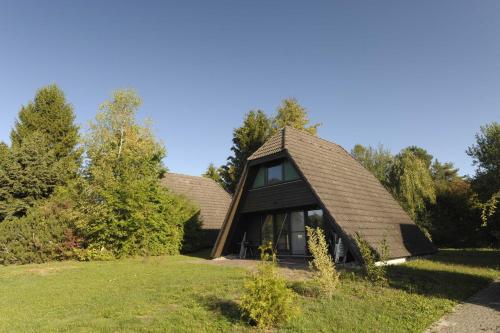 ein kleines Haus mit einem Dach auf einem Grasfeld in der Unterkunft Ferienhaus Winnetou Schwarzkittelpfad 85 in Waldbrunn