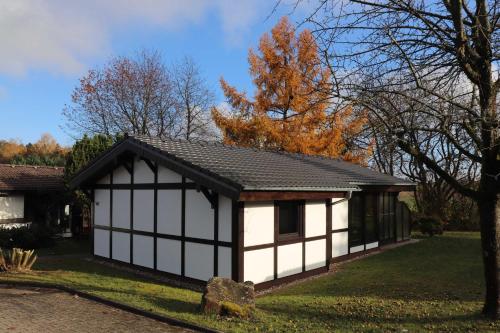 a white and black shed with a black roof at Ferienhaus Robinson Romantikpfad 161 in Waldbrunn