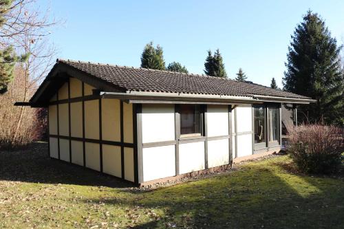a small house with a white and black garage at Ferienhaus Robinson Im Abendrot 123 in Waldbrunn