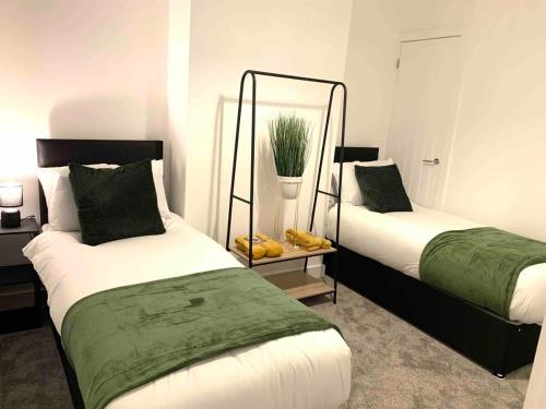 a bedroom with two beds and a mirror at The Hughenden Townhouse / Free Parking / Wifi in Leicester
