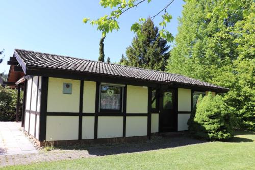 a small white and black building in a yard at Ferienhaus Robinson Sonnenkreisel 133 in Waldbrunn