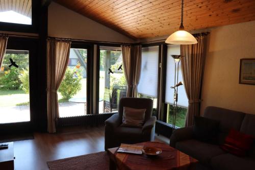 a living room with a couch and a table and windows at Ferienhaus Robinson Sonnenkreisel 133 in Waldbrunn