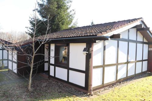 ein kleines weißes und schwarzes Gebäude mit einem Fenster in der Unterkunft Ferienhaus Scout Paradiesecke 179 in Waldbrunn