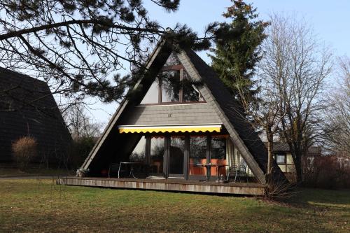 uma pequena casa com um telhado triangular num campo em Ferienhaus Winnetou Am Fuchsbau 67 em Waldbrunn