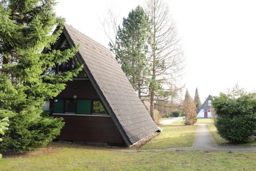 a small house with a pointed roof in a yard at Ferienhaus Winnetou Am Fuchsbau 67 in Waldbrunn