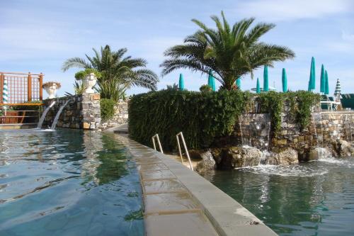 a swimming pool with a waterfall in a resort at Hotel Helios in Santa Margherita Ligure