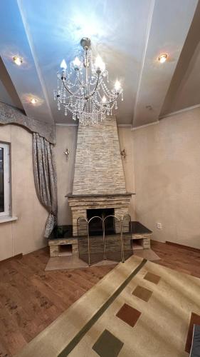 a living room with a fireplace and a chandelier at Хостел in Bishkek