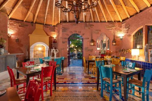 um restaurante com mesas e cadeiras num quarto em Dionysos Hotel em Ixia