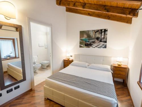 カプリーノ・ヴェロネーゼにあるHotel Villa Cariolaのベッドルーム1室(ベッド1台付)、バスルーム(鏡付)