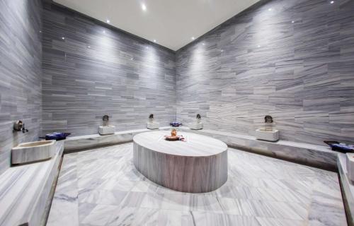 a waiting room with a table and a stone wall at Rixos Premium Dubrovnik in Dubrovnik