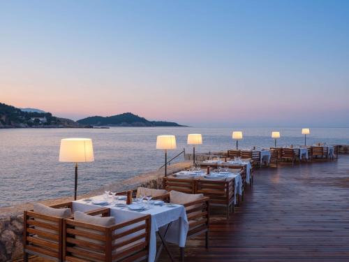 a row of tables on a dock next to the water at Rixos Premium Dubrovnik in Dubrovnik