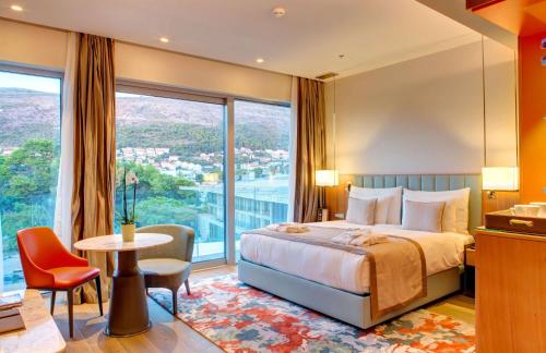 a hotel room with a bed and a large window at Rixos Premium Dubrovnik in Dubrovnik