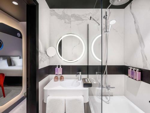 La salle de bains est pourvue d'un lavabo et d'une douche. dans l'établissement TRIBE Budapest Stadium, à Budapest