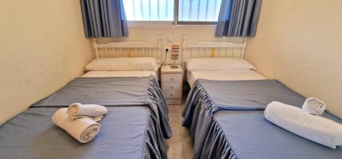 duas camas num pequeno quarto com toalhas em Los Ranchos, B-3 em Benidorm