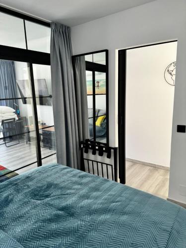 a bedroom with a bed and large glass windows at Modern premium apt-Europa Apartamentos near CCYumbo in Playa del Ingles