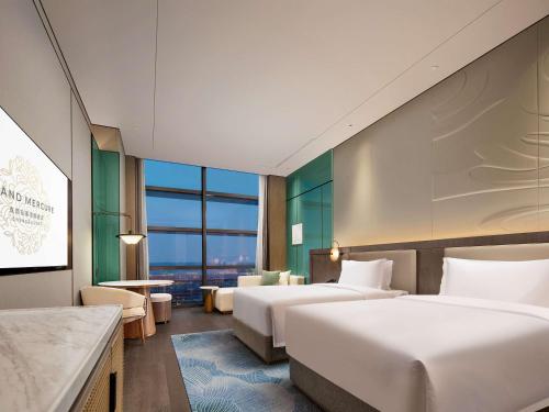 a hotel room with two beds and a large window at Grand Mercure Chengdu East in Chengdu