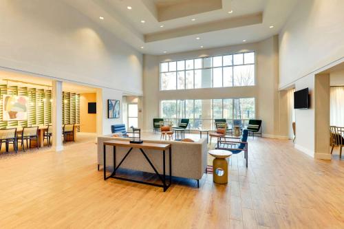 a lobby with a large room with tables and chairs at Sonesta Select San Francisco Airport Oyster Point Waterfront in South San Francisco